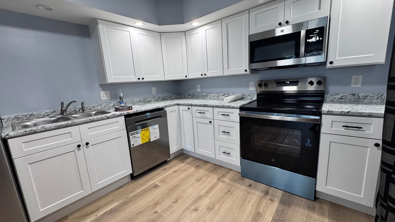 Finished kitchen with white shaker cabinets and stainless appliances