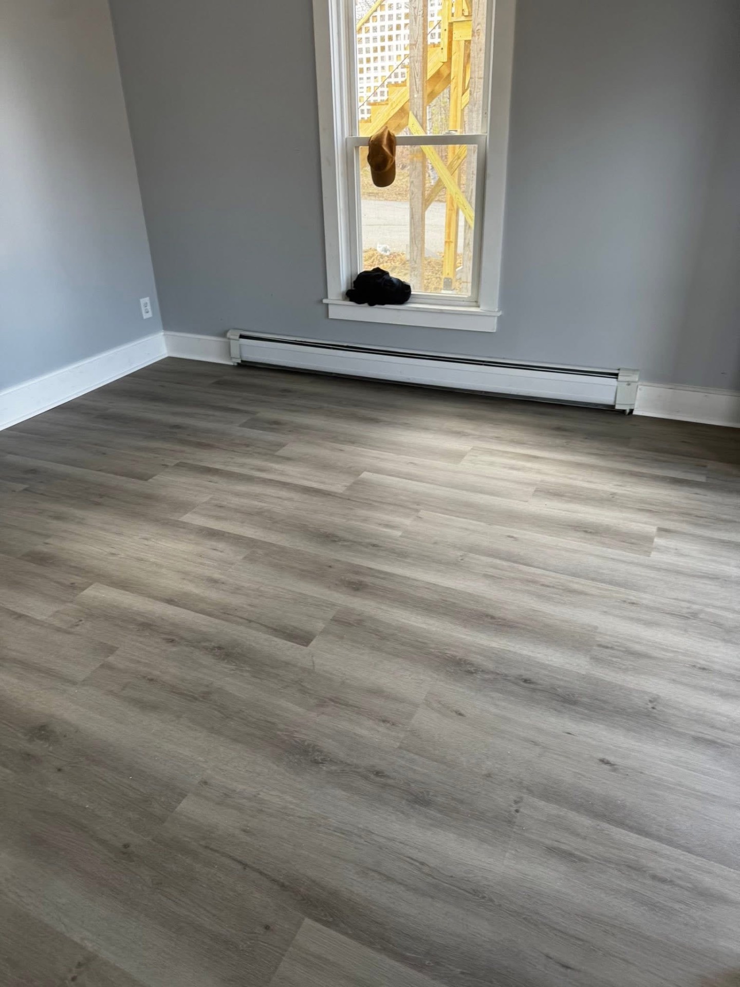 Same bedroom with new gray vinyl plank flooring installed