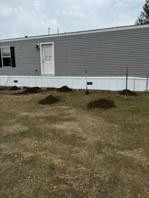 Bare backyard with dug post holes ready for a new deck build